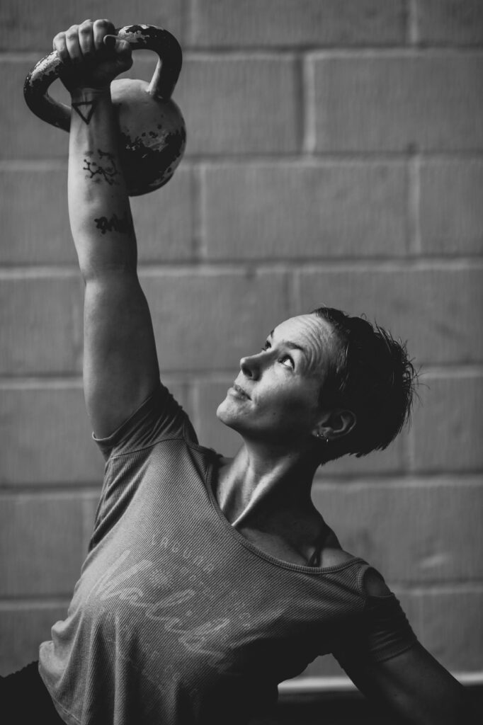 Strong woman with kettlebell performing windmill