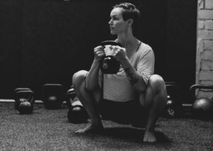 strong woman in kettlebell squat in kenilworth